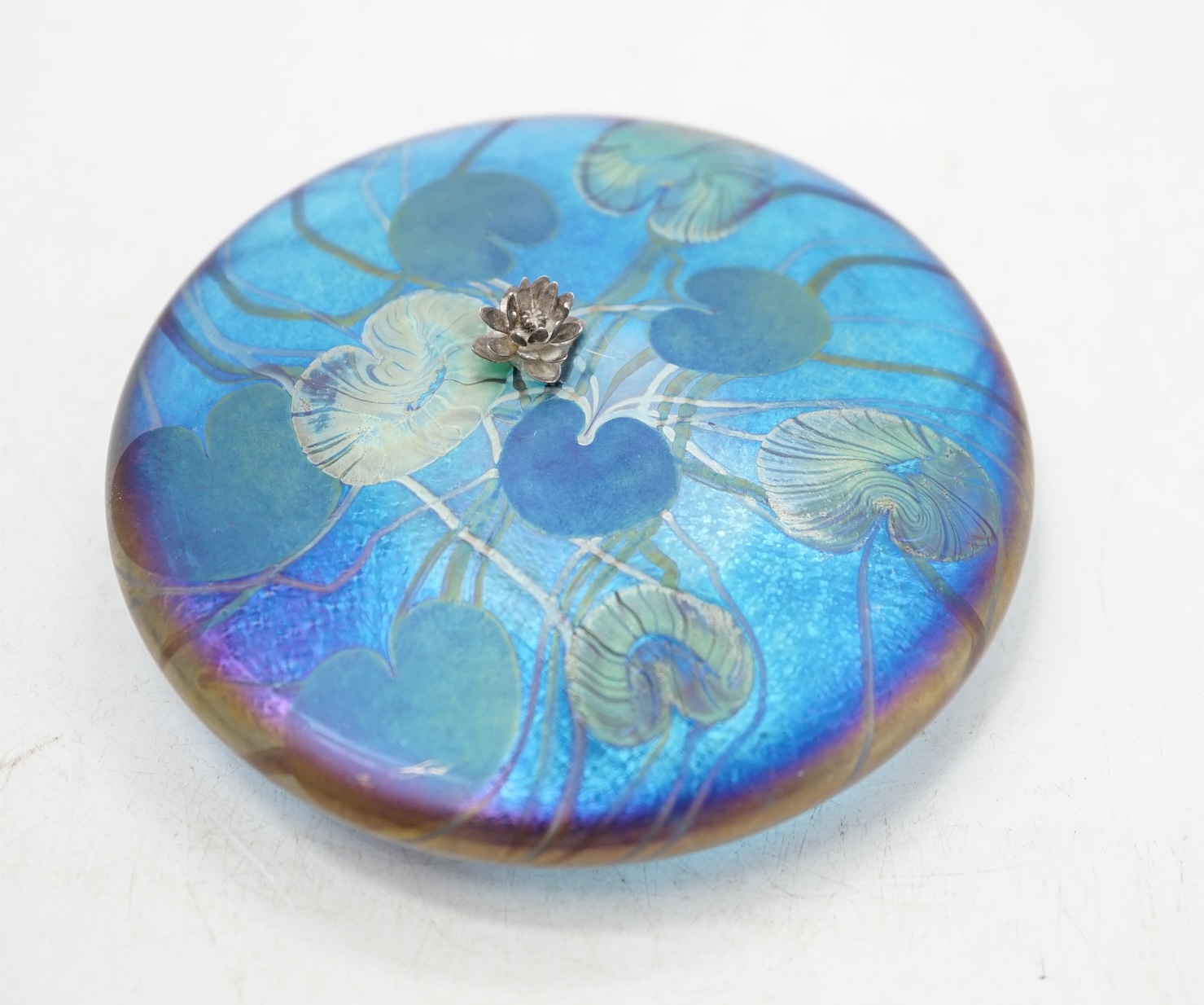 A John Ditchfield for Glasform paperweight, disc shaped with lily pad decoration and metal frog mounted in the centre,11cm diameter. Condition - frog needs re-gluing, glass paperweight good